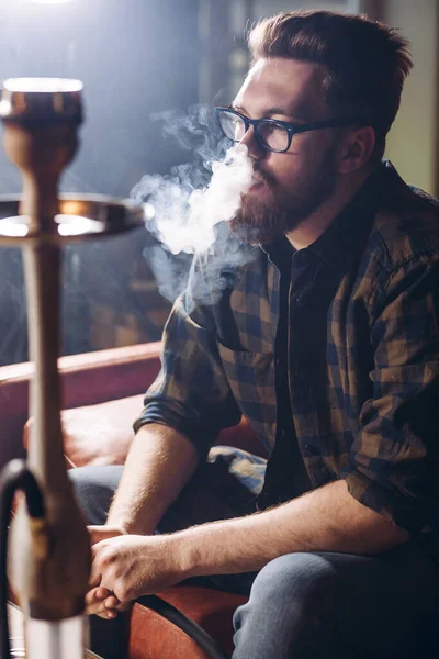 Thoughtful man looking at the smoke from the hookah — Stock Photo, Image