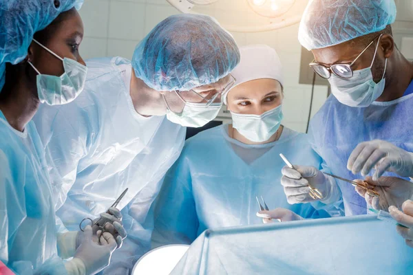 Equipo trabajador de cirujanos en el trabajo en el quirófano. — Foto de Stock