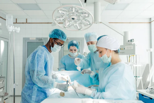 Médicos abriendo el abdomen en el quirófano —  Fotos de Stock