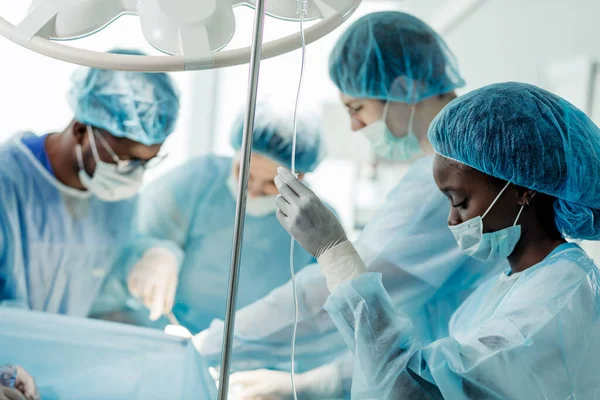 Joven anestesista impresionante pone el gotero en la habitación del hospital — Foto de Stock