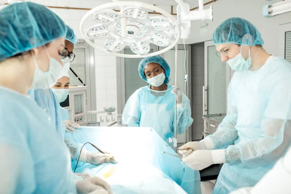 Enfermera cansada grave sosteniendo gotero y mirando el proceso de operación —  Fotos de Stock