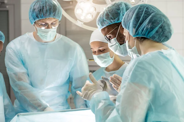 Läkare och sjuksköterskor som ger behandling genom en öppning i kroppen. — Stockfoto