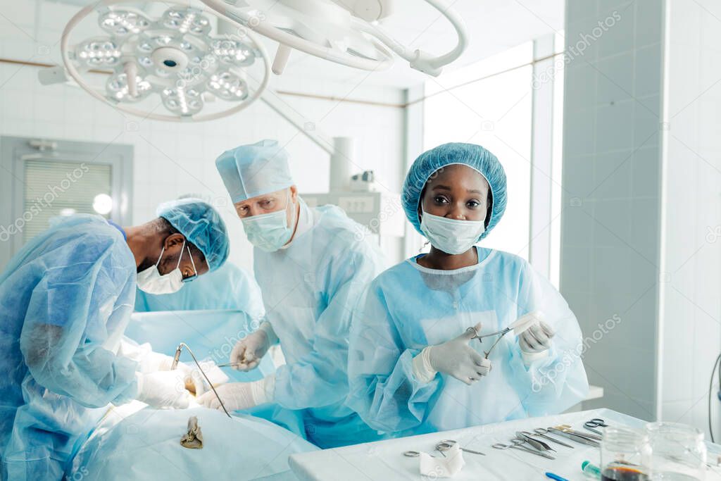 attractive assistant using scissors while performing operation