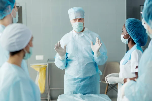 Professionell läkare i mask diskuterar detaljer om ett medicinskt ingrepp — Stockfoto