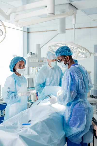 Африканські та кавказькі лікарі проводять ризиковану операцію — стокове фото