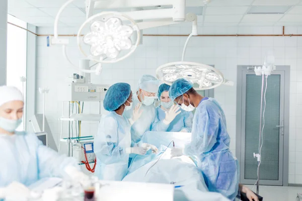 Senior läkare med upphöjda händer i handskar är redo att utföra riskfyllda operationer — Stockfoto