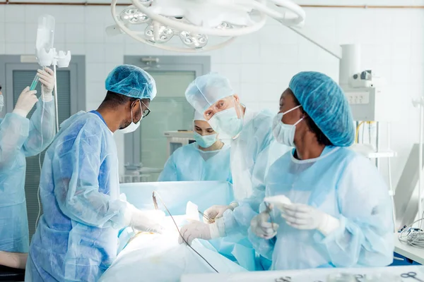 Врачи, работающие с пациентом в операционной — стоковое фото