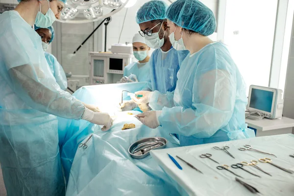 Médicos en uniforme especial untando crema antibiótica en la herida — Foto de Stock