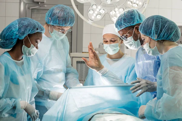 Potilas nostaa kätensä nukkuessaan leikkauksen aikana — kuvapankkivalokuva