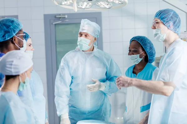 Gyönyörű sebész és csapata kitalál egy munkatervet. — Stock Fotó