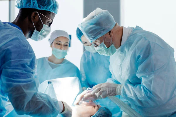 Técnicos de raza mixta cubren a los pacientes nariz y boca —  Fotos de Stock