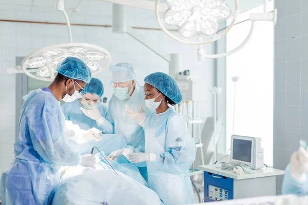 Fantastici medici di razza mista, infermieri condurre operazioni — Foto Stock