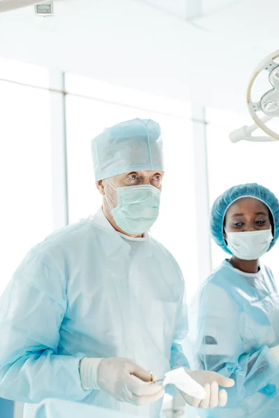 Médico senior hablando con sus asistentes sobre cirugía futura —  Fotos de Stock