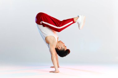 Bboy akrobatik hareketler yapıyor. Sokak sanatçıları açık havada break dans yapıyor.