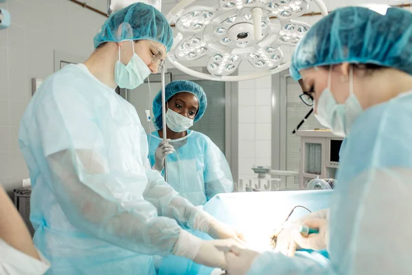 Хірурги, що виконують попередньо заброньовані або екстрені операції з командою — стокове фото