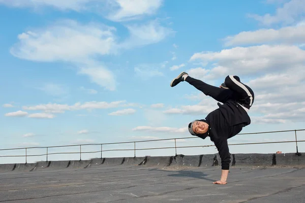 Asiático hip-hop hombre bailarín haciendo un backdancing acrobacias al aire libre en el techo — Foto de Stock