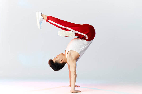 Asian Bboy standing in freeze stunt upside down balancing in air with legs