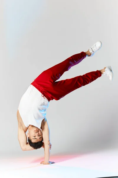 Handstand koreanischer Breakdancer führt Breakdance-Freeze auf weißem Grund auf — Stockfoto