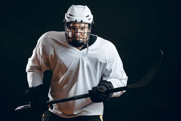 Imagen del jugador de hockey sobre hielo en ropa deportiva blanca sosteniendo palo de hockey —  Fotos de Stock