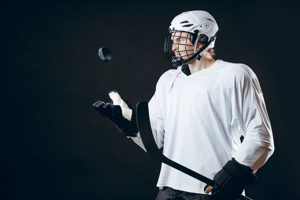 Retrato de jugador de hockey sobre hielo con palo de hockey y disco aislado sobre negro —  Fotos de Stock