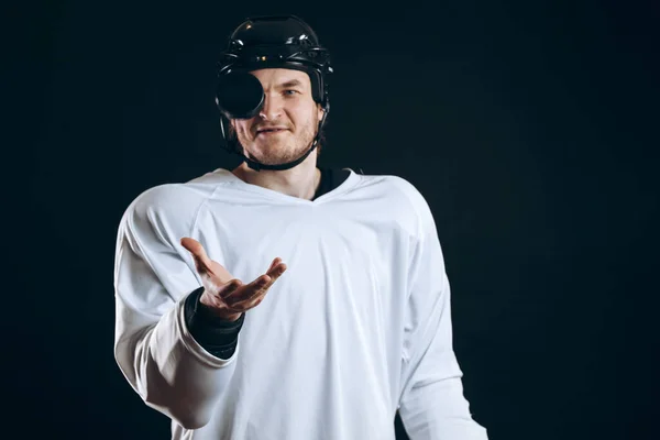 Jugador de hockey muerde el disco con los dientes rotos y mirando a la cámara con una sonrisa. —  Fotos de Stock