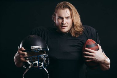 Kararlı Amerikan futbolcusu siyah arka planda izole edildi