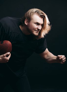 Kararlı Amerikan futbolcusu siyah arka planda izole edildi