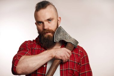 Siyah arka planda baltayla tıraş olan sakallı bir adam.