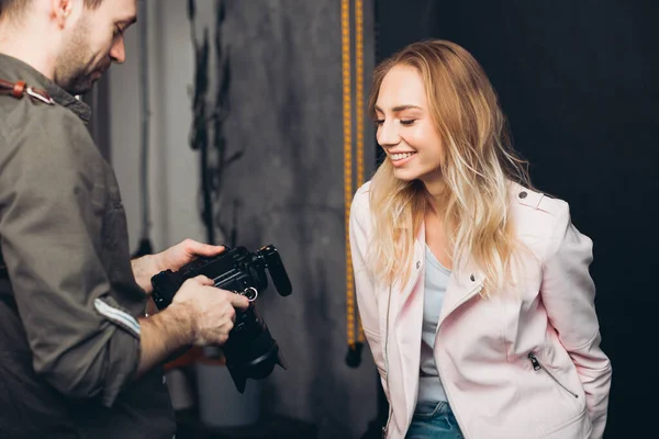 Fotograf pokazuje uroczej dziewczynie zdjęcia przed kamerą. — Zdjęcie stockowe