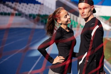 Gülümseyen pozitif sporcu kadın ciddi erkek arkadaşına bakıyor.