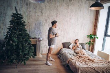 İki çekici eşcinsel erkek Noel ağacıyla yatak odasında vakit geçiriyorlar..