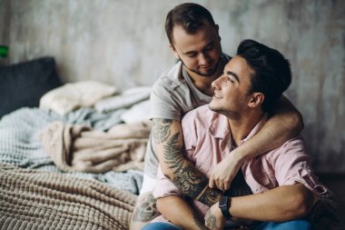 İki seksi beyaz gay sarılmış ve yatakta eğleniyor.
