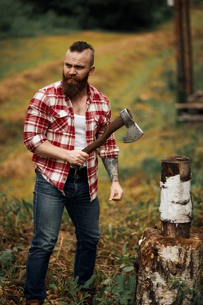 Woodcutter in shirt chopping firewoods, chips fly apart — Stock Photo, Image