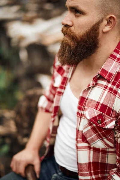 Man hipster med skägg på allvarliga ansikte trasa skjorta — Stockfoto