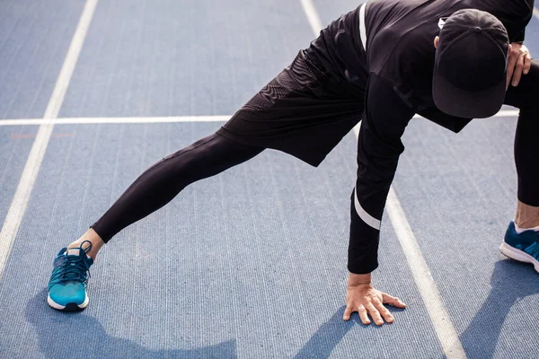 Fit sportsman warming up on the road. close up image — Stock Photo, Image