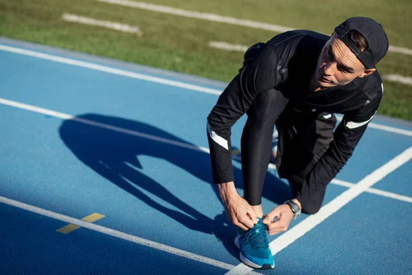 Atleta guapo atando sus risitas — Foto de Stock