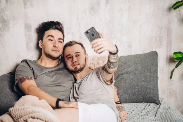 Feliz gay casal tomando selfie no cama no casa — Fotografia de Stock