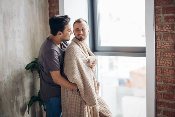 Deux beaux gars homosexuels tout en se tenant près de la fenêtre — Photo