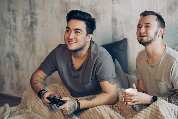 Mañana perfecta comienza con amante y café en la cama. Dos tíos descansando en la cama . — Foto de Stock