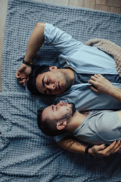 Schöner schläfriger Mann mit Borsten küsst gute Nacht männlicher Partner im Bett liegend — Stockfoto