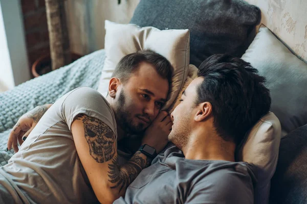 Ένα ομοφυλόφιλο ζευγάρι στο κρεβάτι σε στούντιο με πατάρι εσωτερικό — Φωτογραφία Αρχείου