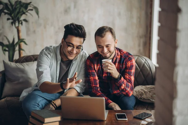 Europeiska homosexuella manliga par tillbringar tid tillsammans dricka kaffe och titta på laptop — Stockfoto