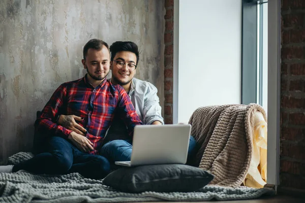 Europeiska homosexuella manliga par tillbringar tid tillsammans dricka kaffe och titta på laptop — Stockfoto