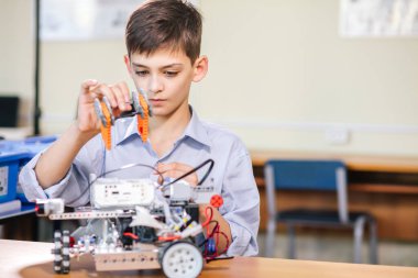 Robot okulundaki küçük çocuk robot yapıyor.