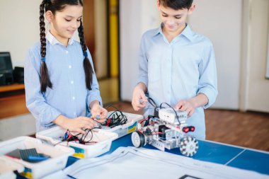 İki çocuk, iki kardeş ve onların hobi-yapıcı robot oyuncakları.