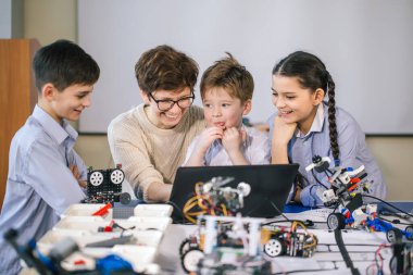 Mutlu çocuklar ders dışı derslerde dizüstü bilgisayar kullanarak programlama öğrenirler.