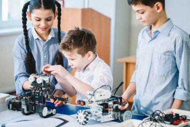Robot sergisini ziyaret ederken çocuklar elektrikli robotla oynuyorlar