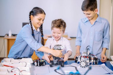 Robot sergisini ziyaret ederken çocuklar elektrikli robotla oynuyorlar