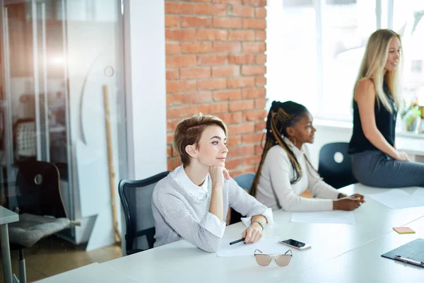 Blondes schönes stilvolles Mädchen am Tisch mit nachdenklichem Blick — Stockfoto