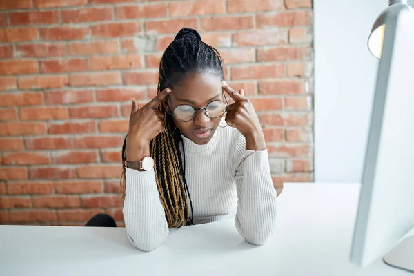 Trött afro kontorsarbetare som har huvudvärk — Stockfoto